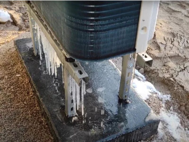 Jednostka zewnętrzna pompy ciepła zimą podczas odszraniania.